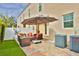 Charming outdoor patio with stylish seating, a large umbrella, and a serene backyard view at 3222 W Empedrado St, Tampa, FL 33629