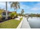 Canal-front backyard featuring lush tropical landscaping, dock and patio at 5809 Cruiser Way, Tampa, FL 33615