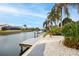 Canal-front backyard featuring a dock, lush landscaping and tropical trees at 5809 Cruiser Way, Tampa, FL 33615