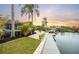 Waterfront backyard with lush tropical landscaping, a private dock, and direct water access at 5809 Cruiser Way, Tampa, FL 33615