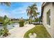 A serene backyard with tropical landscaping, paver path, and canal view at 5809 Cruiser Way, Tampa, FL 33615
