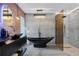 Modern bathroom features a sleek black soaking tub, glass shower, and unique lighting fixtures at 5809 Cruiser Way, Tampa, FL 33615