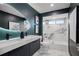 Modern bathroom featuring a dual vanity, marble tile, and a unique mirror for a luxurious aesthetic at 5809 Cruiser Way, Tampa, FL 33615
