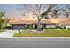 Charming single-story home featuring a terracotta roof, well-manicured lawn, and lovely landscaping at 5809 Cruiser Way, Tampa, FL 33615