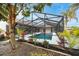 Backyard view of the screened-in pool, landscaping and mature trees at 5809 Cruiser Way, Tampa, FL 33615
