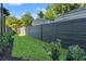 A view to the backyard with green grass, plants, and a high privacy fence at 807 W Park Ave, Tampa, FL 33602