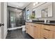 Modern bathroom featuring sleek black tiled shower and stylish wood vanity with black hardware and black countertops at 807 W Park Ave, Tampa, FL 33602