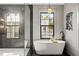 Bright bathroom featuring a glass walk-in shower, stand alone tub, and black tile flooring at 807 W Park Ave, Tampa, FL 33602