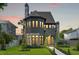 Charming two-story home showcasing stone accents, a well-manicured lawn at sunset at 807 W Park Ave, Tampa, FL 33602