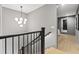 Hallway and stairway with a modern chandelier, wood floors, and a view into the adjacent living spaces at 807 W Park Ave, Tampa, FL 33602