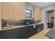 Modern kitchen showcasing dark countertops and backsplash with wood cabinets and stainless-steel appliances at 807 W Park Ave, Tampa, FL 33602