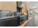 Gourmet kitchen featuring black countertops, stainless steel appliances, and wood cabinets for a sleek modern look at 807 W Park Ave, Tampa, FL 33602