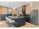 A kitchen with black island and light wood cabinets has modern light fixtures and stainless steel appliances at 807 W Park Ave, Tampa, FL 33602