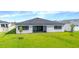 Lush backyard with a modern home featuring a covered patio at 8347 Golden Beach Ct, Parrish, FL 34219