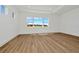Bright bedroom with large window, tray ceiling, and light wood-look flooring at 8347 Golden Beach Ct, Parrish, FL 34219