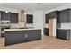 This kitchen has stainless steel appliances, a modern range hood, and dark modern cabinetry at 8347 Golden Beach Ct, Parrish, FL 34219