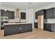 This kitchen has stainless steel appliances, a large center island with a white countertop and ample dark cabinetry at 8347 Golden Beach Ct, Parrish, FL 34219