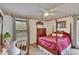 Comfortable bedroom with a four-poster bed, floral wallpaper accents, and large windows at 13108 Dobree Pl, Riverview, FL 33579