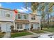 Charming two-story townhome with light blue shutters and door, surrounded by lush greenery at 8615 Hunters Key Cir, Tampa, FL 33647