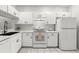 Bright kitchen featuring white cabinets, appliances, and sleek black hardware at 8615 Hunters Key Cir, Tampa, FL 33647