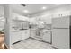 Well-lit kitchen with white appliances, cabinets, and tile flooring at 8615 Hunters Key Cir, Tampa, FL 33647