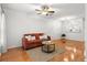 Bright living room featuring hardwood floors, a comfortable sofa, and a modern ceiling fan at 8615 Hunters Key Cir, Tampa, FL 33647