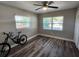 Bright bedroom features wood floors, ceiling fan, and two windows at 907 Knollwood Dr, Dunedin, FL 34698