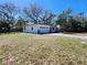 Home exterior featuring a well-manicured lawn, attached garage, and freshly painted facade at 907 Knollwood Dr, Dunedin, FL 34698