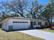 Charming single-story home featuring an attached two-car garage and a well-maintained front yard at 907 Knollwood Dr, Dunedin, FL 34698