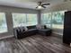 Bright living room featuring a gray couch, wood-look flooring, and tons of natural light at 907 Knollwood Dr, Dunedin, FL 34698