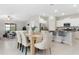 Open-concept living and dining area with kitchen island, stainless appliances, and modern furnishings at 9805 Lemon Drop Loop, Sun City Center, FL 33573