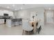 Open-concept dining area with modern decor, kitchen island with breakfast bar, and natural light at 9805 Lemon Drop Loop, Sun City Center, FL 33573