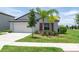 Well-maintained single-Gathering home with a lush green lawn, landscaping, and a two-car garage at 9805 Lemon Drop Loop, Sun City Center, FL 33573