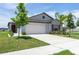 Well-maintained single-Gathering home with a lush green lawn, landscaping, and a two-car garage at 9805 Lemon Drop Loop, Sun City Center, FL 33573