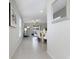 Bright hallway leading to an open floorplan with a dining table and living area at 9805 Lemon Drop Loop, Sun City Center, FL 33573