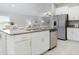 Modern kitchen features granite countertops, stainless steel appliances, and white cabinetry at 9805 Lemon Drop Loop, Sun City Center, FL 33573