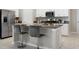 Stylish kitchen island with granite countertops, bar stool seating, and stainless steel appliances at 9805 Lemon Drop Loop, Sun City Center, FL 33573