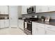 Modern kitchen featuring stainless steel appliances, granite countertops, and ample cabinet space at 9805 Lemon Drop Loop, Sun City Center, FL 33573
