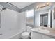 Bathroom features a white tiled shower/tub combination, toilet, and white vanity at 10815 Wrigley Ct, Riverview, FL 33579