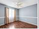 Bedroom featuring hardwood floors, window with curtains and blinds, and ceiling fan with light at 10815 Wrigley Ct, Riverview, FL 33579