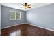Bedroom featuring hardwood floors, window with blinds, and ceiling fan with light at 10815 Wrigley Ct, Riverview, FL 33579