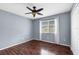 Bedroom featuring hardwood floors, window with curtains and blinds, and ceiling fan with light at 10815 Wrigley Ct, Riverview, FL 33579