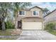 Charming two-story home features a two-car garage, landscaped yard, and mature trees in a suburban neighborhood at 10815 Wrigley Ct, Riverview, FL 33579