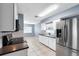 Bright kitchen features white cabinets, stainless steel appliances, a dark countertop, and tile floors at 10815 Wrigley Ct, Riverview, FL 33579