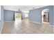 Open-concept living room boasts tile floors, a ceiling fan, gray walls, and sliding glass doors to the backyard at 10815 Wrigley Ct, Riverview, FL 33579