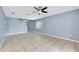 Spacious living room features tile flooring, neutral paint, a ceiling fan, and a view of the staircase at 10815 Wrigley Ct, Riverview, FL 33579