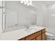 Modern bathroom featuring a spacious mirror, wood-finished vanity, white countertop, and clean, white tiles at 12660 Glenn Creek Dr, Riverview, FL 33569