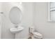 Powder room features pedestal sink, oval mirror, and toilet at 12660 Glenn Creek Dr, Riverview, FL 33569