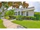 Charming single-story home featuring a covered porch, well-manicured lawn, and lush landscaping at 217 Oceania Ct, Apollo Beach, FL 33572