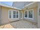 Covered patio with brick flooring and a bay window looking out onto yard at 217 Oceania Ct, Apollo Beach, FL 33572